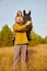 A rural couple with a horse in a natural yellow landscape on an autumn day. Young man and woman together with an animal