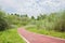 Rural curving red-painted path in cloudy summer