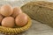 Rural eggs lying in a basket near bread