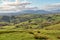 A rural English scene with grazing sheep and rolling countryside on a sunny day.