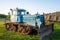 Rural farm field landscape. Soviet blue crawler bulldozer, front view