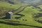 Rural farming stone barn in highland field.