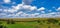 Rural farmland concept. Panoramic view of cornfield and blue sky