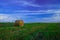 Rural field agriculture stack of hay green grass and blue sky vivid colorful idyllic landscape scenic view of September autumn