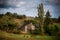 Rural french landscape with farmhouse, grazing  brown cows, and dramatic sky ,lozere , France