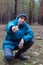 A rural guy posing in a pine forest in the autumn time.