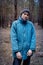 A rural guy posing in a pine forest in the autumn time.