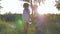 Rural holidays, little boy and small girl circling and jumping holding hands at sunset