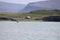 Rural house on the shore against the background of mountains. Reykjavik, Iceland.