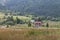 Rural houses on slope of forested mountains.