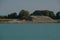 Rural idyll on a quarry pond in bavaria, excavation lake with big pile of sand and gravel after dig up