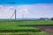 Rural idyllic landscape. Green field and light sky with small cl