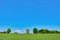 Rural idyllic landscape scenery view with green meadows and blue sky on spring day