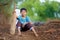 Rural Indian Child sitting on ground with bat