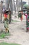 Rural Indian Villagers Women and girls cut firewood from protected nature reserve area, carry heavy loads on head walking miles,