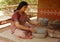 Rural Indian woman figure using stone grinder to make flour