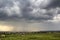 Rural land for development in green field. New not finished brick and wooden houses on background of distant village and high city