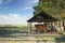 Rural landscape: barn car under an old shed, pasture, gate and blue sky clouds