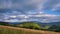 Rural landscape in the Carpathians with moving dense clouds, dry grassy meadow. 4K timelapse