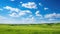 Rural landscape of green grassland with idyllic blue sky background