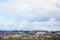 A rural landscape with many private houses and green trees. Suburban panorama on a cloudy afternoon. A place far from the cit