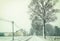 Rural landscape with road and farm under snowfall in winter