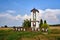 Rural landscape with a roadside shrine with a statue of the Virgin Mary