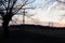 Rural landscape with willow trees and cross near a river in early spring during sunset in the evening before dusk