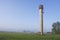 Rural morning landscape with water tower and mist fog