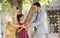 Rural mother and daughter receiving piggy bank from businessman