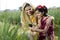 Rural mother and daughter using mobile phone on agriculture field