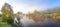 Rural panorama with river, fog and forest at sunrise