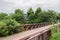 Rural planked footbridge in cloudy summer afternoon