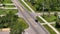 Rural road with driving traffic cars in American small town in Florida. Private homes between green trees and suburban