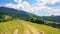 rural road through green meadows on rolling hills