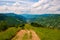 Rural road among green mountain meadows