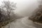 Rural road in the mountains in winter Epirus region, Greece on a cloudy, foggy day