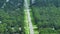 Rural road traffic in American small town in Florida with private homes between green trees and suburban streets in