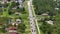 Rural road traffic in American small town in Florida with private homes between green trees and suburban streets in