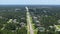 Rural road traffic in American small town in Florida with private homes between green trees and suburban streets in