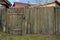 Rural Scene. Run-down wooden fence with wicket for entrance in yard of rural house. From weathered old boards. Close-up