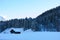 Rural shed at pine tree forest in mountainous region snowy landscape