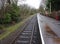 Rural single railway track and train station on a rainy day