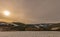 Rural snowy winter idyllic farmland countryside with sun and light clouds