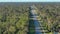 Rural street traffic with driving cars in Florida small town. American suburban landscape with private homes in quiet