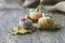 Rural three crocheted handmade pumpkins on autumn oak leaves and bagging, selective focus, side view