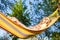 Rural Vacation Concepts. Young Caucasian Blond Girl Relaxing In Hammock In Green Forest Outdoors