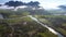 Rural valley with road houses trees and rivers against hills