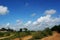 A rural village soily road landscape with blue sky and white clouds background, the nice charming scene.