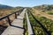 Rural wooden path to village through beautiful natural landscape, Portugal. Green hills in peaceful area of Algarve